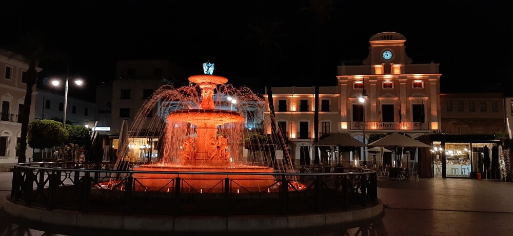 Fachada y fuente iluminadas en naranja