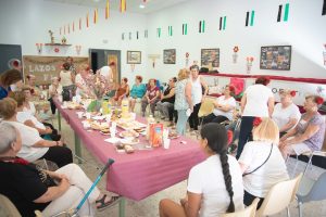 Las personas mayores que participan en el Programa Lazos, en la zona de Nueva Ciudad, disfrutan de su desayuno y actividades de Feria